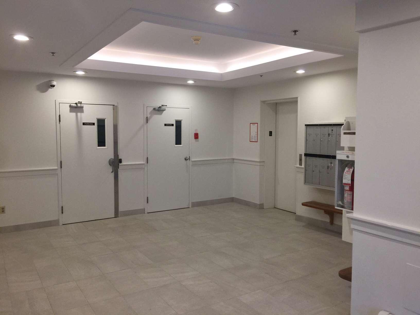 a large room with white walls and a tiled floor